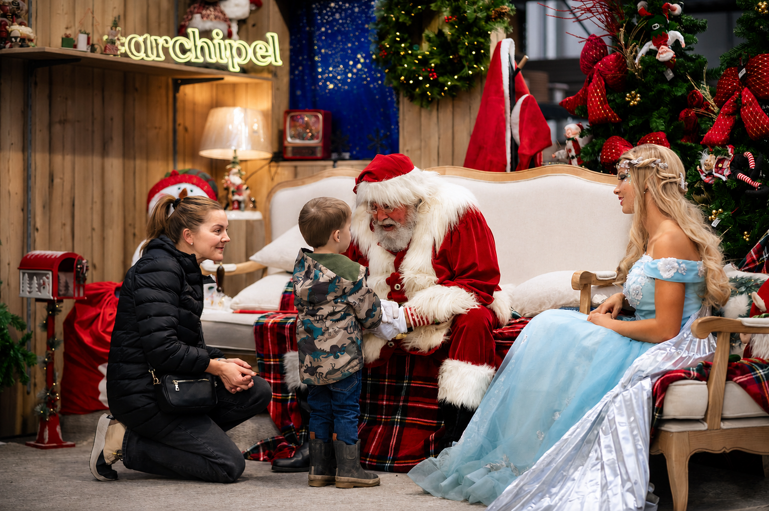 Le Père Noël assis dans un fauteuil de velours, clochette à la main, à la Lutinerie de Montréal.