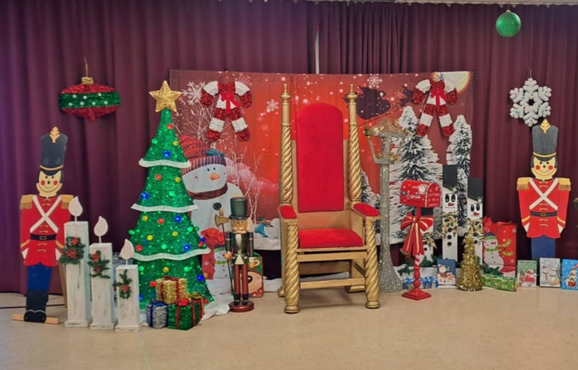 Décor moyen : trône doré, sapin illuminé et soldats de bois.