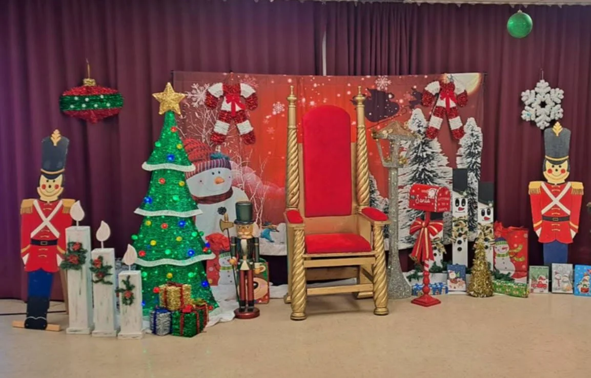 Décor moyen : trône doré, sapin illuminé et soldats de bois.