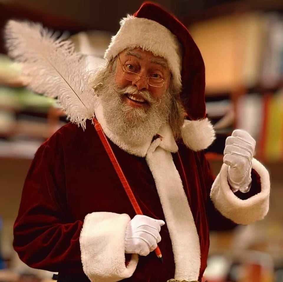 Le Père Noël Denniss, barbe naturelle et lunettes rondes.