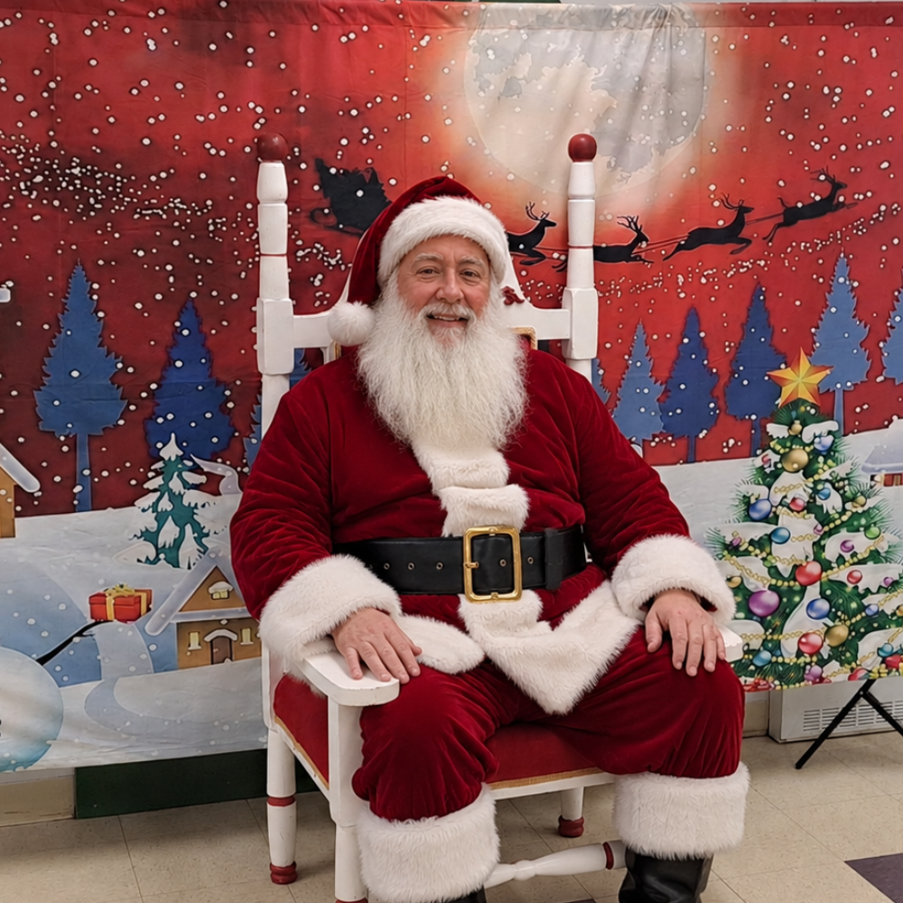 Le Père Noël Michel assis sur son trône devant un décor de fenêtre enneigée.
