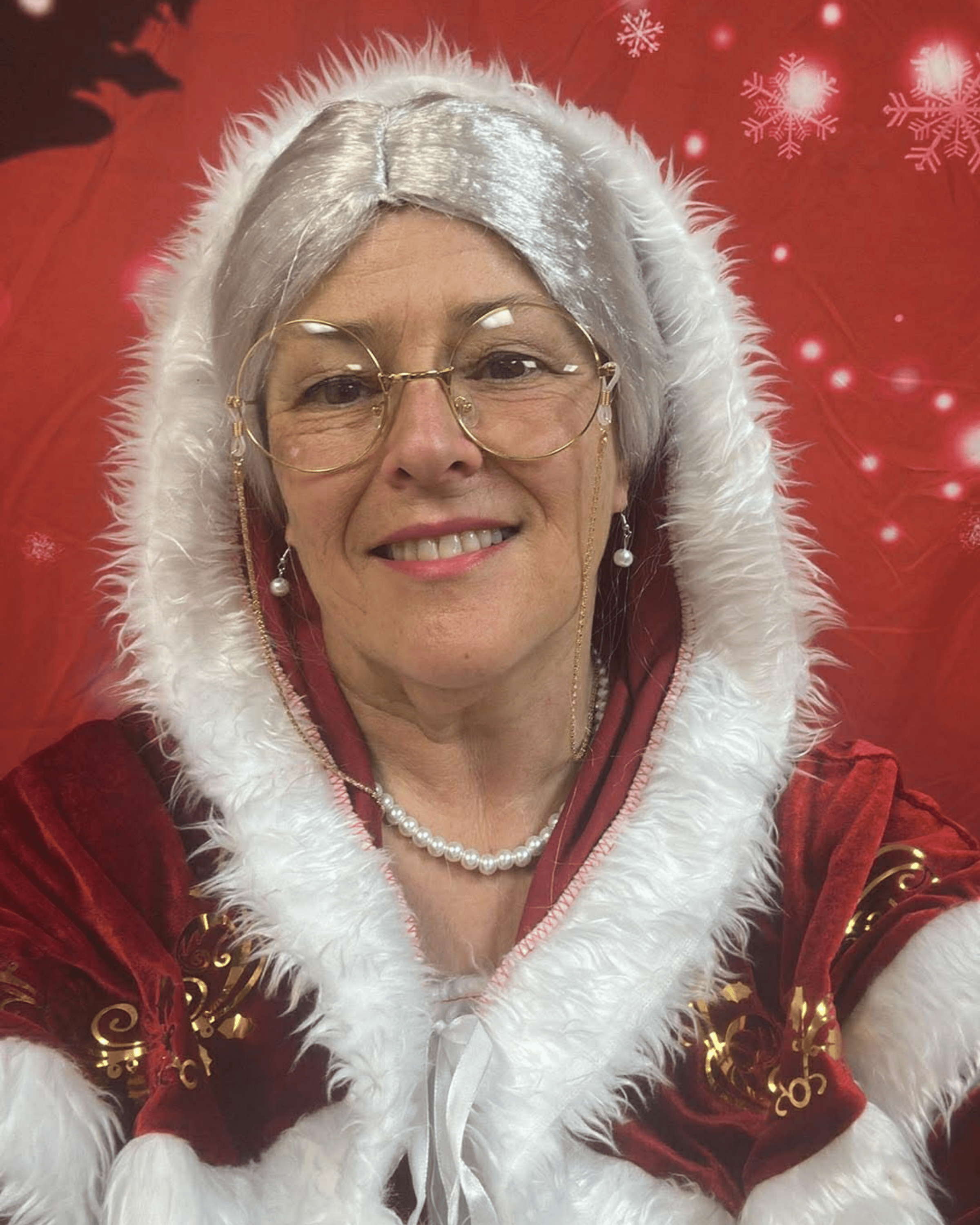 Maman Noël dans son salon de Noël, près du sapin et du foyer.