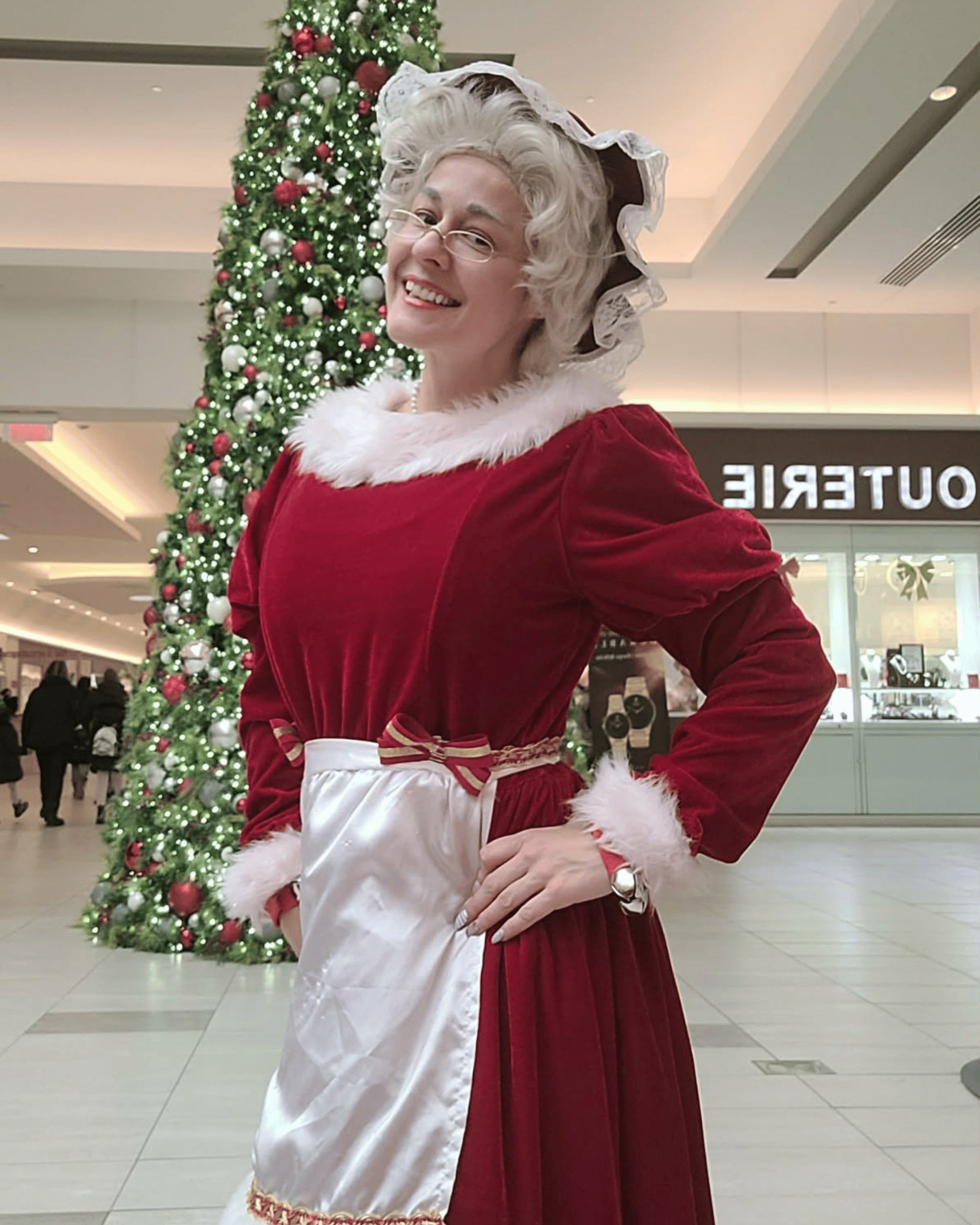 Maman Noël dans son salon de Noël, près du sapin et du foyer.