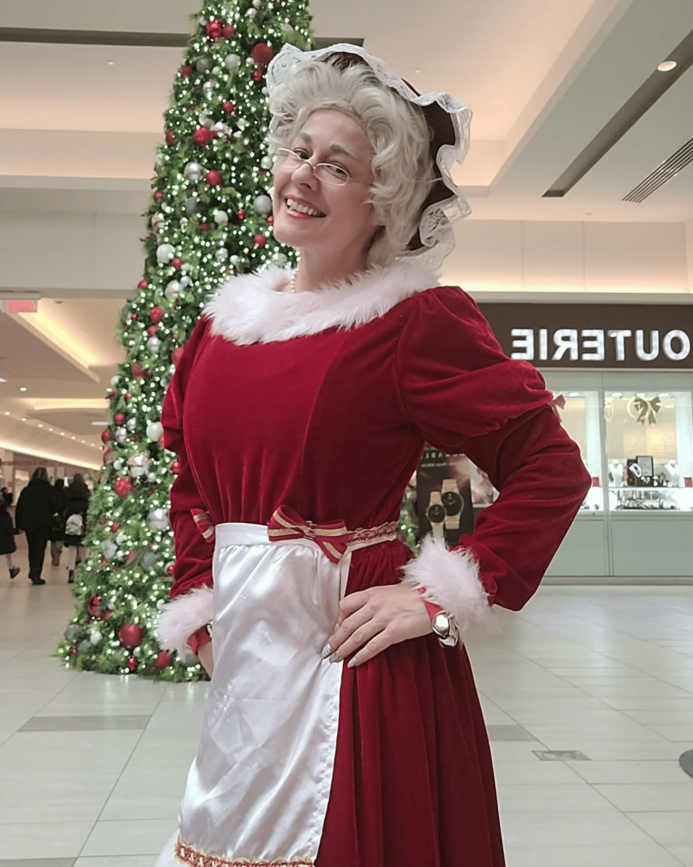 Maman Noël dans son salon de Noël, près du sapin et du foyer.