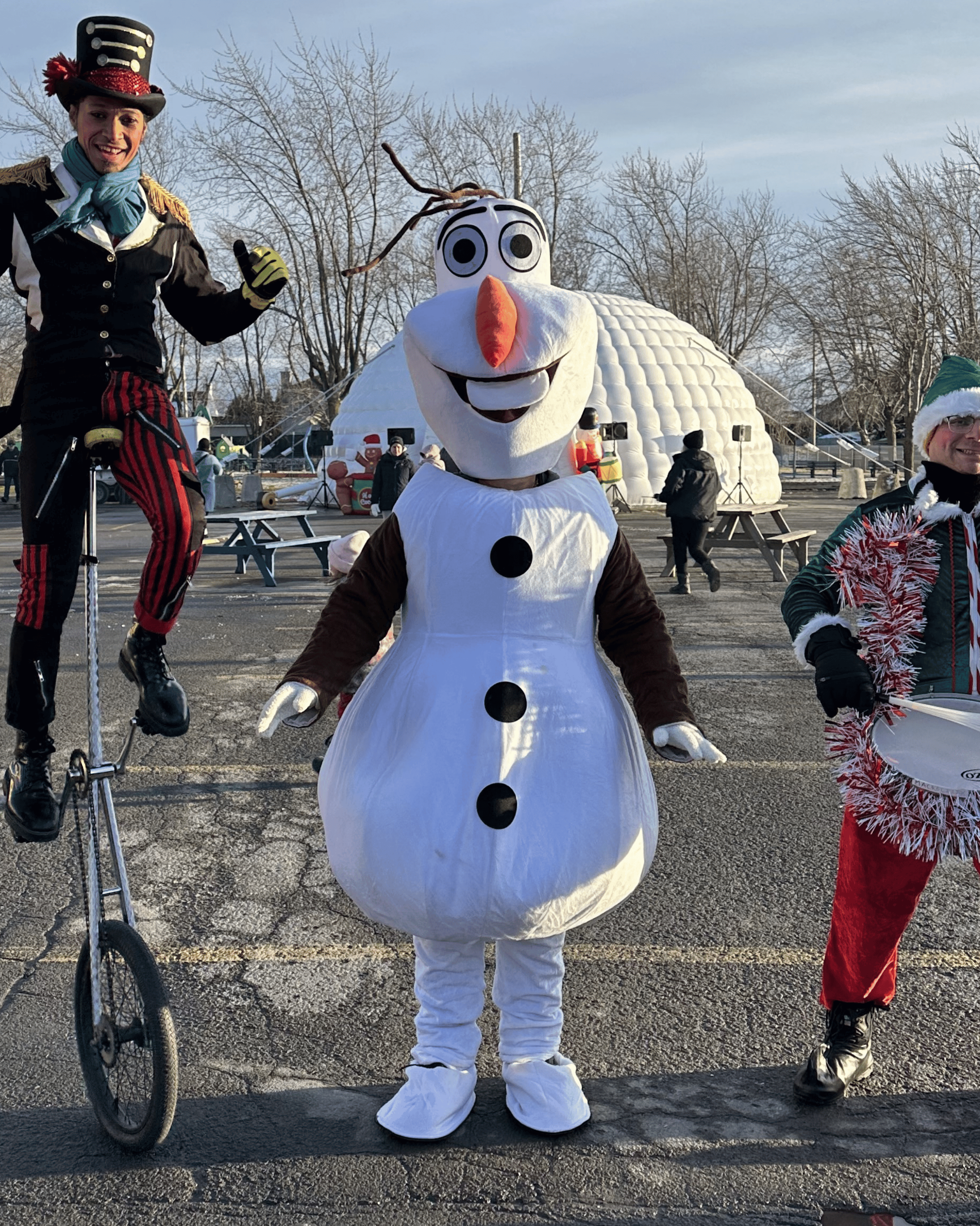 Olaf entouré des jongleurs et lutins devant l'igloo géant.