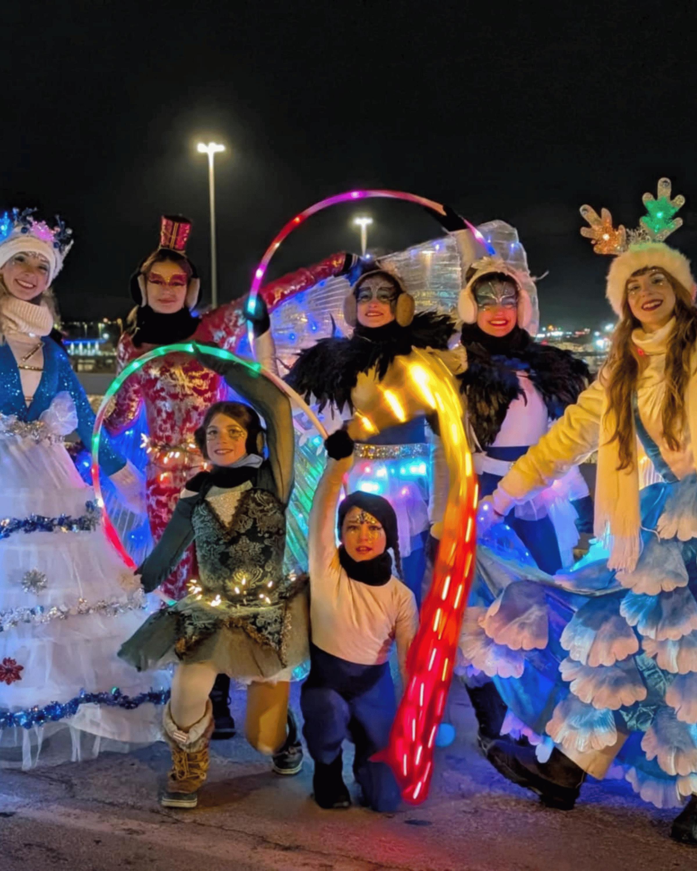 La troupe de parade en costumes lumineux, cerceaux LED en main.